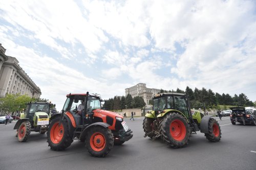 Fermierii ies în stradă cu tractoare și mașini agricole 